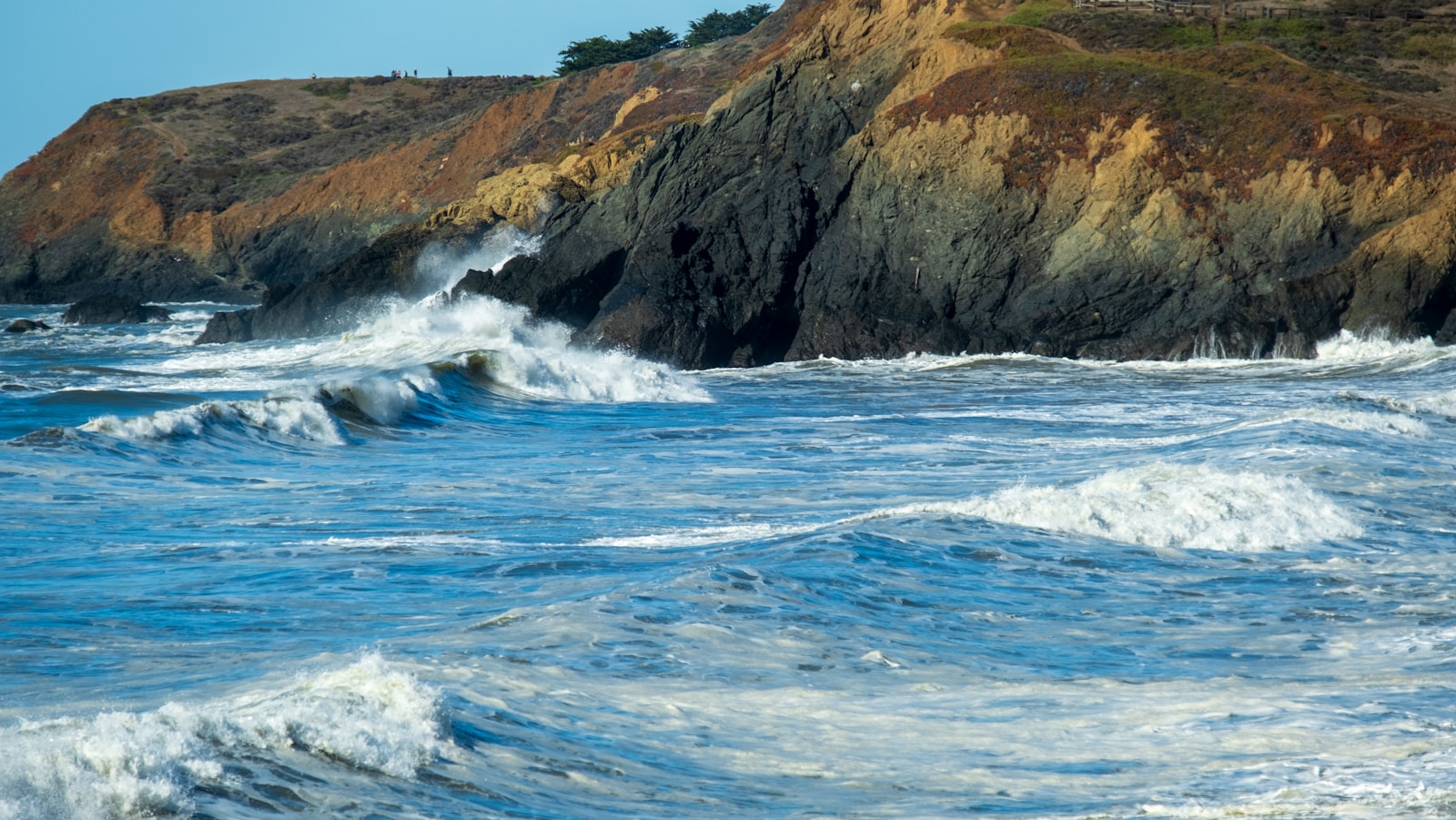 A lighthouse on a cliff overlooking the ocean